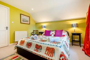 a bedroom with a large bed with colorful pillows at Little Lanherne Farm Cottage in Saint Mawgan