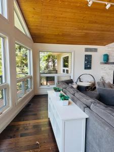 a living room with a couch and a table at Luxurious Lakefront Cottage, Sleeps 12 in Bewdley