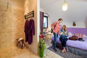 a man and a woman are standing in a bedroom at CHAMBRES D HÔTES ROMANCE AVEC SPA PRIVATISÉ ! Le LUXE EN TOUTE INTIMITÉ in Doutre +6 photos