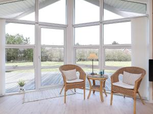 a room with a table and chairs and windows at Luxury Retreat in Vorupor - By Traum Ferienwohnungen in Nørre Vorupør