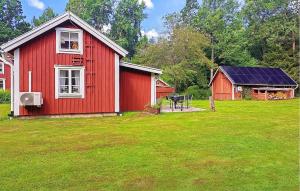 a red barn with a table in a yard at Pet Friendly Home In Malmbäck With Wifi in Malmbäck