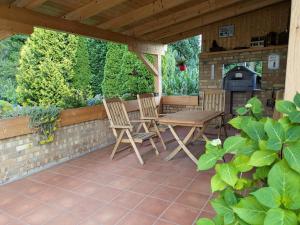 a patio with two chairs and a table and a fireplace at Mansardenwohnung Waldblick in Lichtenstein