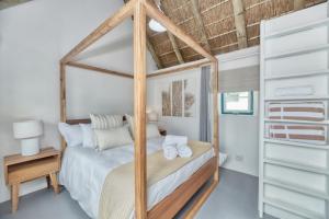 a bedroom with a bed with a wooden frame at Cape Creek Cottage in Struisbaai
