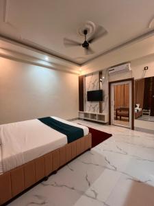 a bedroom with a bed and a flat screen tv at Hotel Pahuna Ghar in Nepālganj