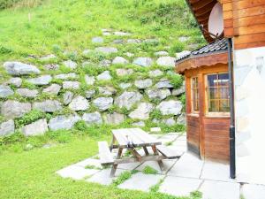 a picnic table and a bench next to a stone wall at Chalet in Rhone Valley near Ski Lift in Les Collons