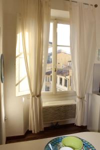 a window with white curtains and a plate on a table at Indipendenza 1 in Florence