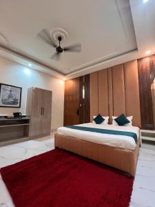 a bedroom with a large bed with a red rug at Hotel Pahuna Ghar in Nepālganj