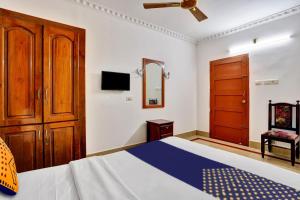 a bedroom with a bed and a wooden cabinet at Hotel O MAJESTIC INN in Chacka +21 photos