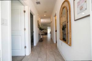 een gang met een spiegel aan de wand en een gang met een gang bij Splendid 5Bd Close to Disney at Storey Lake 4251 in Kissimmee