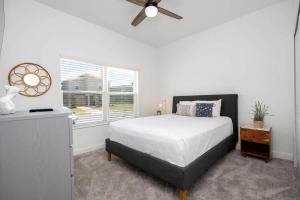 een slaapkamer met een bed en een plafondventilator bij Splendid 5Bd Close to Disney at Storey Lake 4251 in Kissimmee