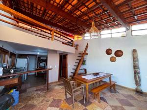 a kitchen and dining room with a wooden table at Casarão Boutique Casaboa in Itacaré