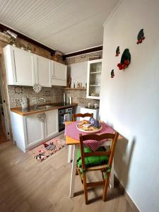 a kitchen with a table and a white refrigerator at Casetta Monti del Duca in Martina Franca