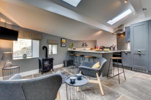 Una cocina y una sala de estar con muebles y una estufa. en The Old Penny Bank, en Hawes