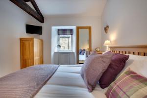Un dormitorio con una gran cama blanca con almohadas. en The Old Penny Bank, en Hawes