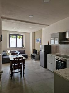 eine Küche und ein Wohnzimmer mit einem Tisch und einer Couch in der Unterkunft Concordia Apartment in Orta San Giulio