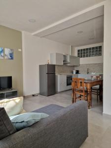 ein Wohnzimmer mit einem Sofa und eine Küche mit einem Tisch in der Unterkunft Concordia Apartment in Orta San Giulio