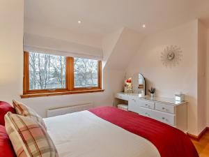 a bedroom with a bed with a red blanket at 3 Bed in Grantown on Spey 94514 in Grantown on Spey