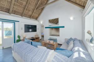a living room with a couch and a tv at Cape Creek Cottage in Struisbaai