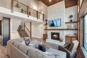 a living room with a couch and a fireplace at Lux Riverfront Retreat- Hot Tub, Game Room, Views! in Lansing