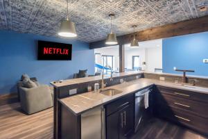 a kitchen with a sink and a tv on the wall at Lux Riverfront Retreat- Hot Tub, Game Room, Views! in Lansing +43 photos