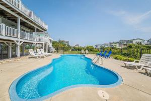a swimming pool in a resort with chairs at Arcadia in Duck