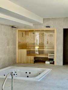 a bath tub in a bathroom with a sink at Rezydencja Niechorze D301 Boho Studio z Basenem i SPA - 5D Apartments in Niechorze +21 photos