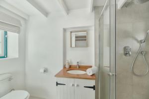 a white bathroom with a sink and a shower at Cape Creek Cottage in Struisbaai +51 photos