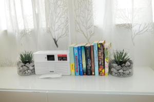 a shelf with books and a microwave and some plants at Ferienwohnungen Spiegel - Fewo lue Heaven in Lindau