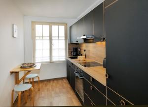 a kitchen with black cabinets and a wooden counter top at Ferienwohnungen Spiegel - Fewo lue Heaven in Lindau