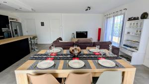 a dining room and living room with a table and chairs at La villa près des Monts du Matin, au pied du Vercors in Saint-Hilaire-du-Rosier