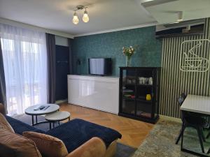 a living room with a couch and a tv at Apartament Nad Nielbą 6Bm2 z ogrodem in Wągrowiec