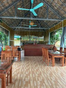 une pièce avec des tables et des chaises en bois et un ventilateur de plafond dans l'établissement May Garden Homestay Ninh Bình, à Phúc Trì