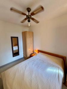 a bedroom with a bed with a ceiling fan at Appartement T2 tout équipé in Port Leucate