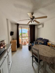 a living room with a ceiling fan and a table at Appartement T2 tout équipé in Port Leucate