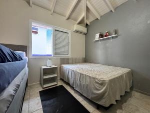 une chambre avec un lit et une fenêtre dans l'établissement CASA PINHEIROS - Casa na Praia de Palmas com 4 Dormitórios e Piscina, à Governador Celso Ramos 17 autres photos