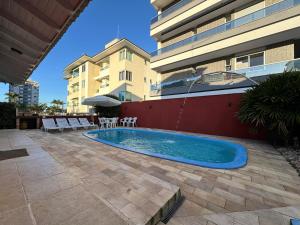 une piscine devant un bâtiment dans l'établissement CASA PINHEIROS - Casa na Praia de Palmas com 4 Dormitórios e Piscina, à Governador Celso Ramos