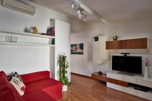 uma sala de estar com um sofá vermelho e uma televisão em La chiave di Volta em Como