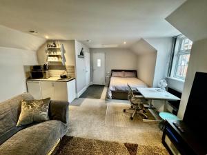 a living room with a couch and a bed and a desk at Guest Room by Amanda & David in Devizes Wiltshire in Bishops Cannings