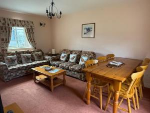 a living room with a table and a couch at The Stable, Magheramore Courtyard in Dungiven