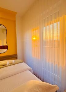a bedroom with two beds and a window at Urban Apartments CityCenter in Gjakove +29 photos