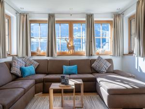 un soggiorno con divano marrone e cuscini blu di Chalet in Bad Hofgastein near Ski Lifts a Bad Hofgastein