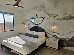 a bedroom with a large bed with a stone wall at Sedona Epic Dream 5BR Pool & Spa Rooftop in Sedona +70 photos