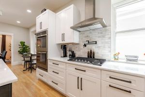 a kitchen with white cabinets and a stove top oven at NEW REMODEL Denver Luxury Home with Private HOT TUB in Denver