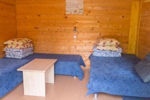 Duas camas e uma mesa num quarto com paredes de madeira em Poilsio nameliai Jūros 67 em Šventoji