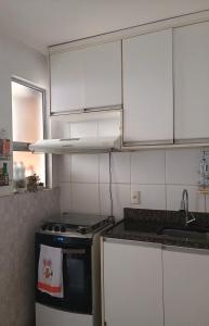 a kitchen with white cabinets and a stove top oven at Casa para COP30 in Marituba