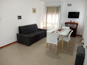 a living room with a black couch and a table at Dpto Toscana in Las Varillas