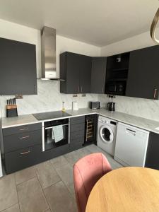 a kitchen with black cabinets and a washing machine at Basin Road 2 Bed House in Chichester