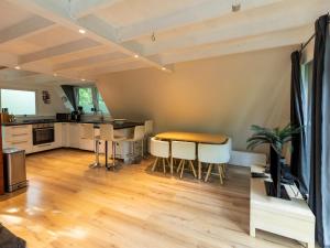 a living room with a table and a kitchen at Lanaken Lakeside Cabin Stay in Lanaken