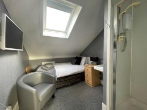 a small bedroom with a bed and a window at Vaila Guest House in Aberdeen