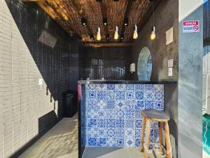 a bar with blue and white tiles and a stool at Porto Privilege by VLV Stays in Salvador